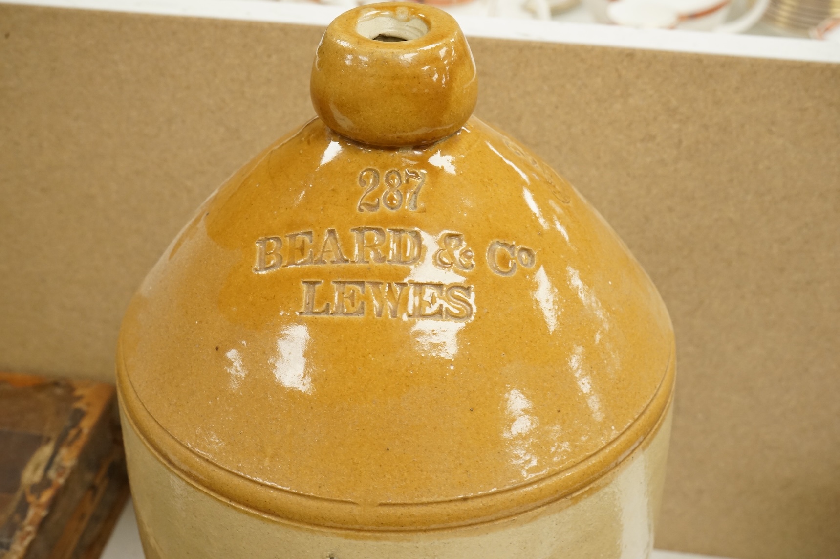 A German earthenware flagon, 32cm tall, together with a Beard & Co of Lewes stoneware liqueur flask